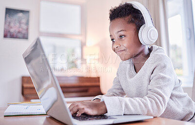Buy stock photo Shot of a young boy doing his homework on a laptop at home