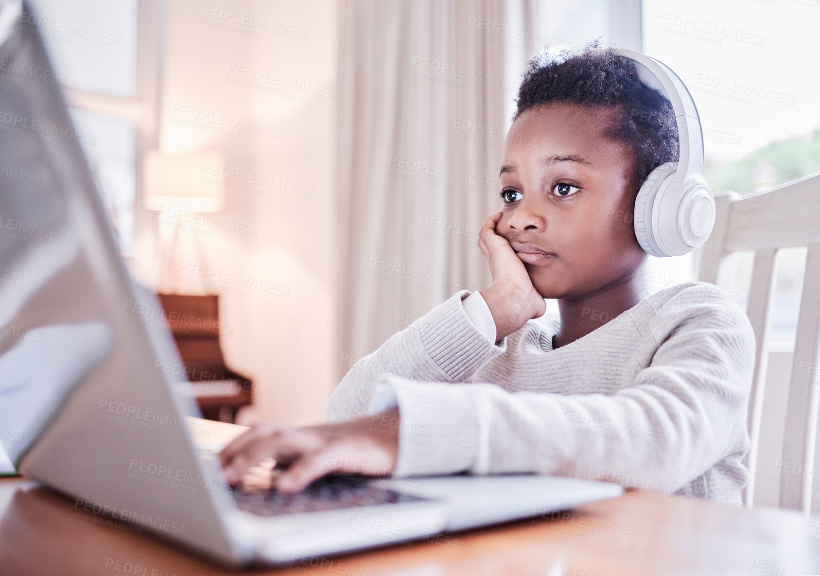 Buy stock photo Shot of a young boy doing his homework on a laptop at home