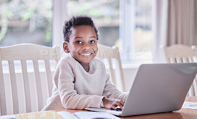 Buy stock photo Shot of a young boy doing his homework on a laptop at home