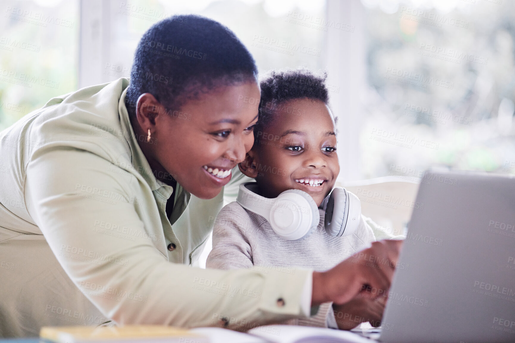 Buy stock photo Shot of a mother helping her son with his homework at home