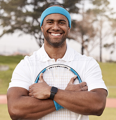 Buy stock photo Shot of a handsome young man standing alone outside and posing with a tennis racket