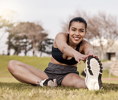 Buy stock photo Full length shot of an attractive young woman sitting alone outside and stretching before playing sports