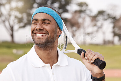 Buy stock photo Shot of a handsome young man standing alone outside and posing with a tennis racket