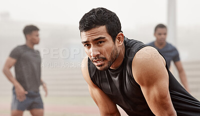 Buy stock photo Shot of a young male athlete catching his breathe during a run