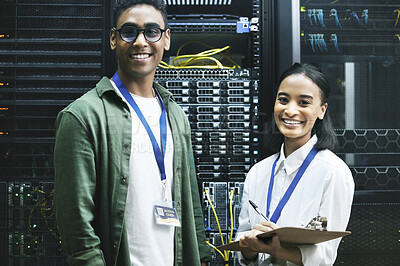 Buy stock photo Shot of two technicians working together in a server room