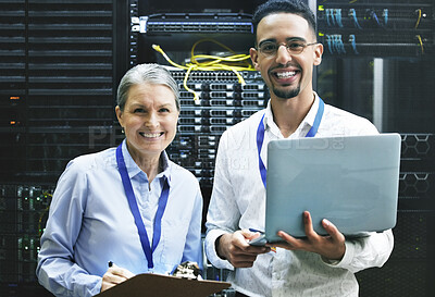 Buy stock photo Shot of two technicians working together in a server room