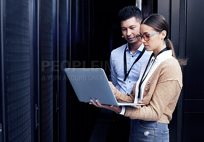Buy stock photo Shot of two technicians working together in a server room