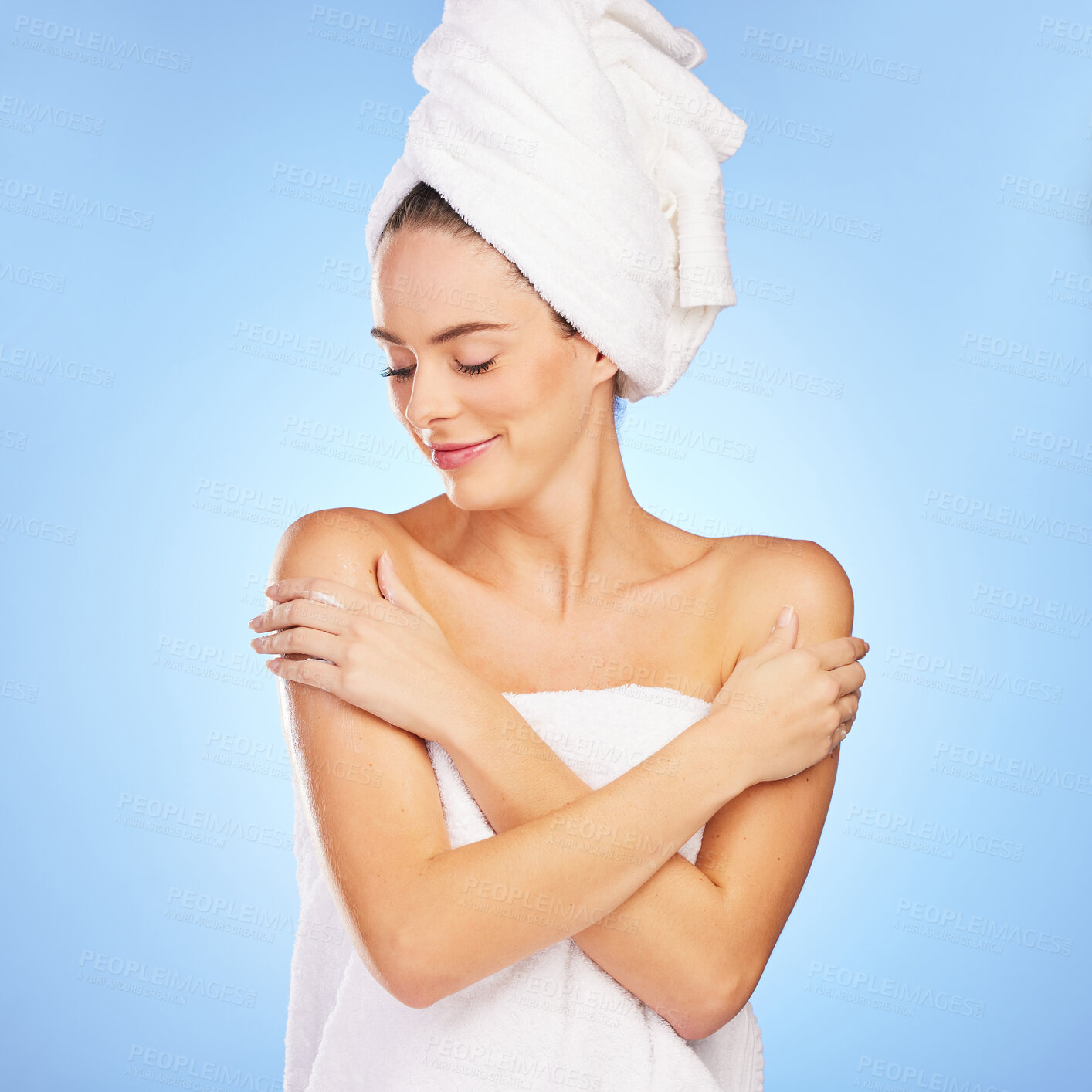 Buy stock photo Shot of a young woman in a towel against a blue background