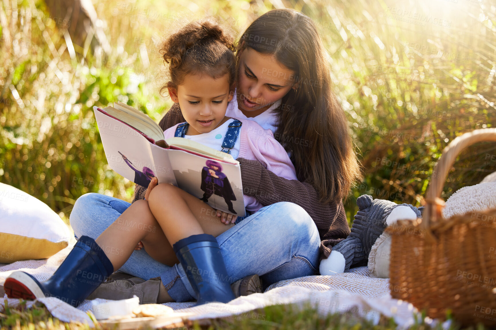 Buy stock photo Mother, child and reading a book in park, love and bonding to connect in childhood at garden. Mama, daughter and relax at outdoor picnic for peace or literature, learning and fiction for storytelling