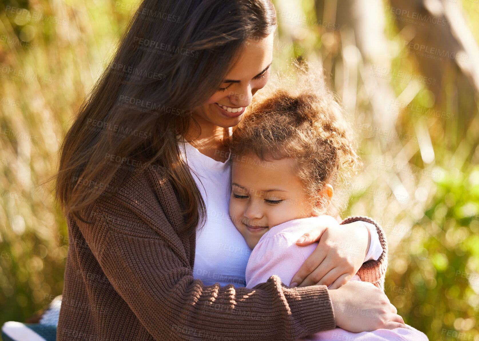 Buy stock photo Cropped shot of an attractive young woman and her daughter sharing an intimate moment during their picnic in the park