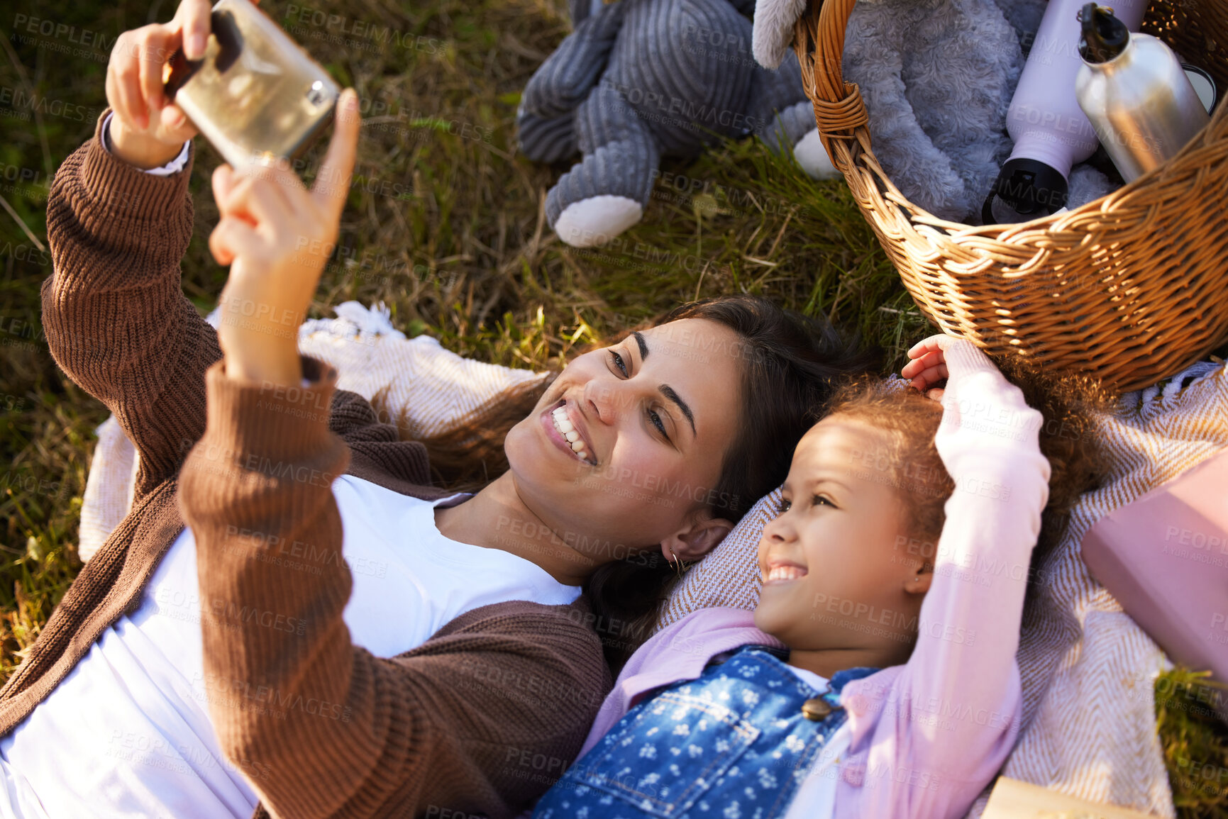 Buy stock photo Mom, child and smile for picnic selfie with bonding together, summer and social media in nature. Mama, young girl and profile picture for happy memory, love relationship and live streaming on grass