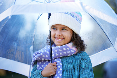 Buy stock photo Shot of an adorable little girl standing alone outside and holding an umbrella