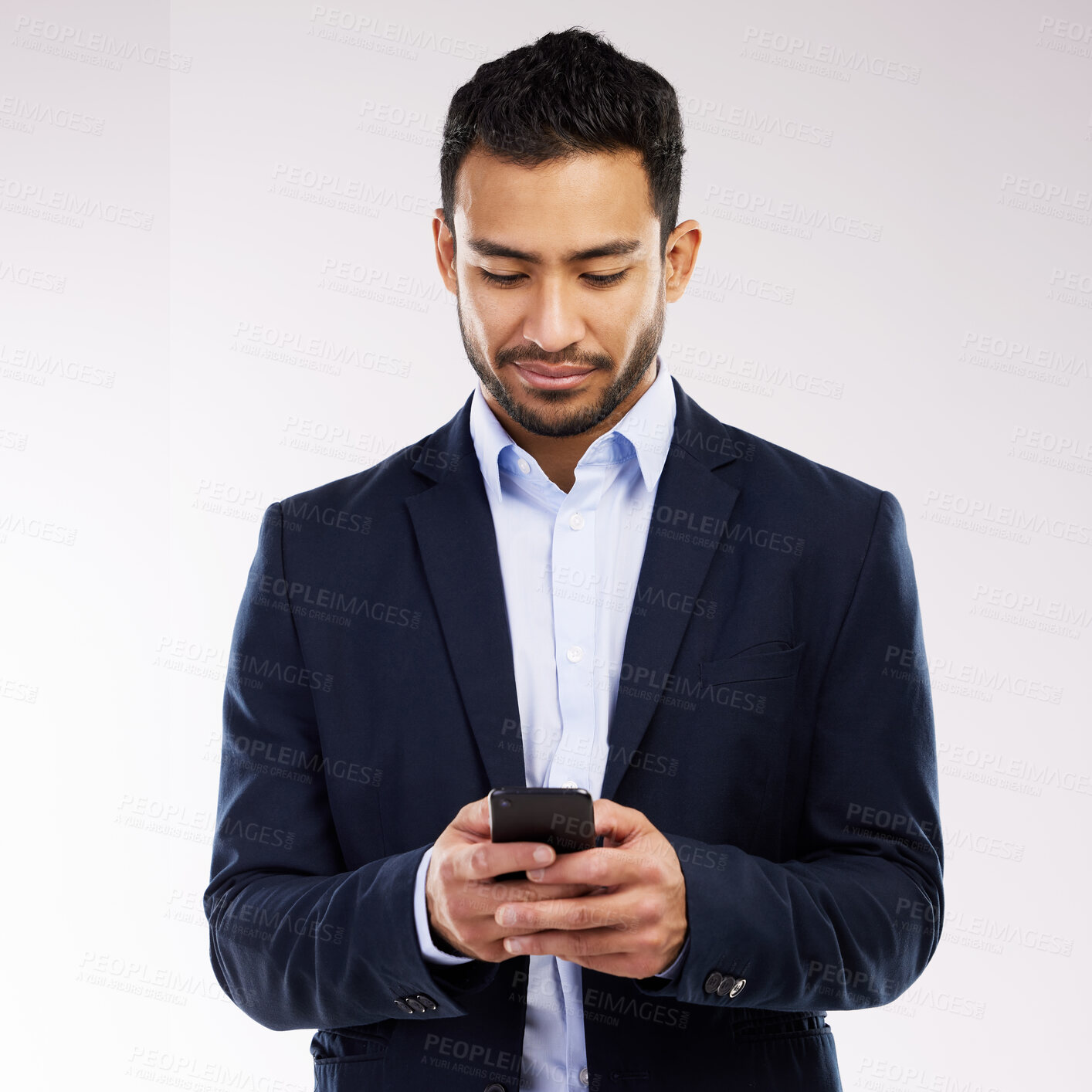 Buy stock photo Studio shot of a young businessman using a cellphone against a white background