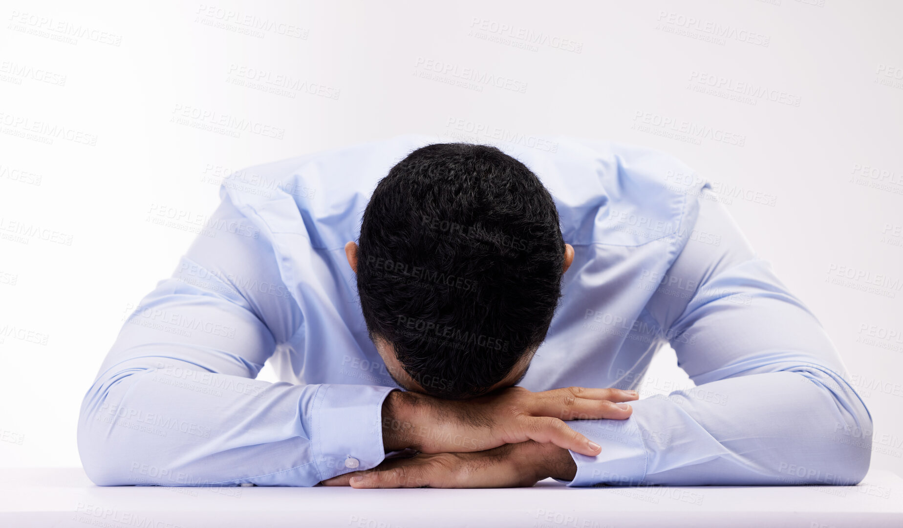 Buy stock photo Studio shot of a young businessman lying with his head down against a white background