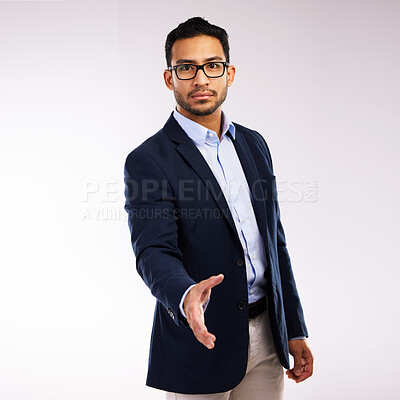 Buy stock photo Studio shot of a handsome young man  extending his arm for a handshake against a grey background