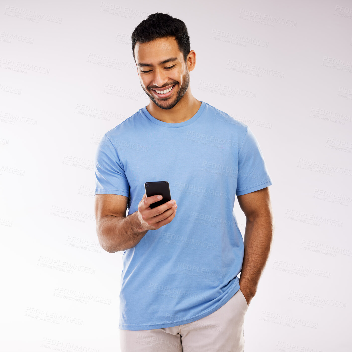 Buy stock photo Studio shot of a young man using a phone against a grey background