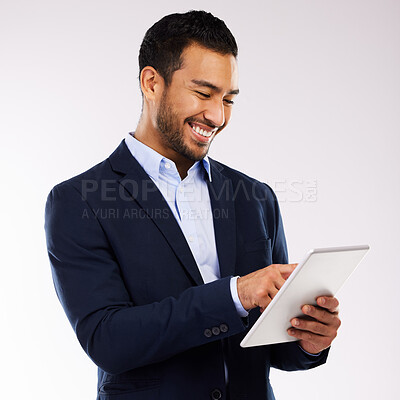Buy stock photo Shot of a handsome man standing alone against a grey background in the studio and using a digital tablet
