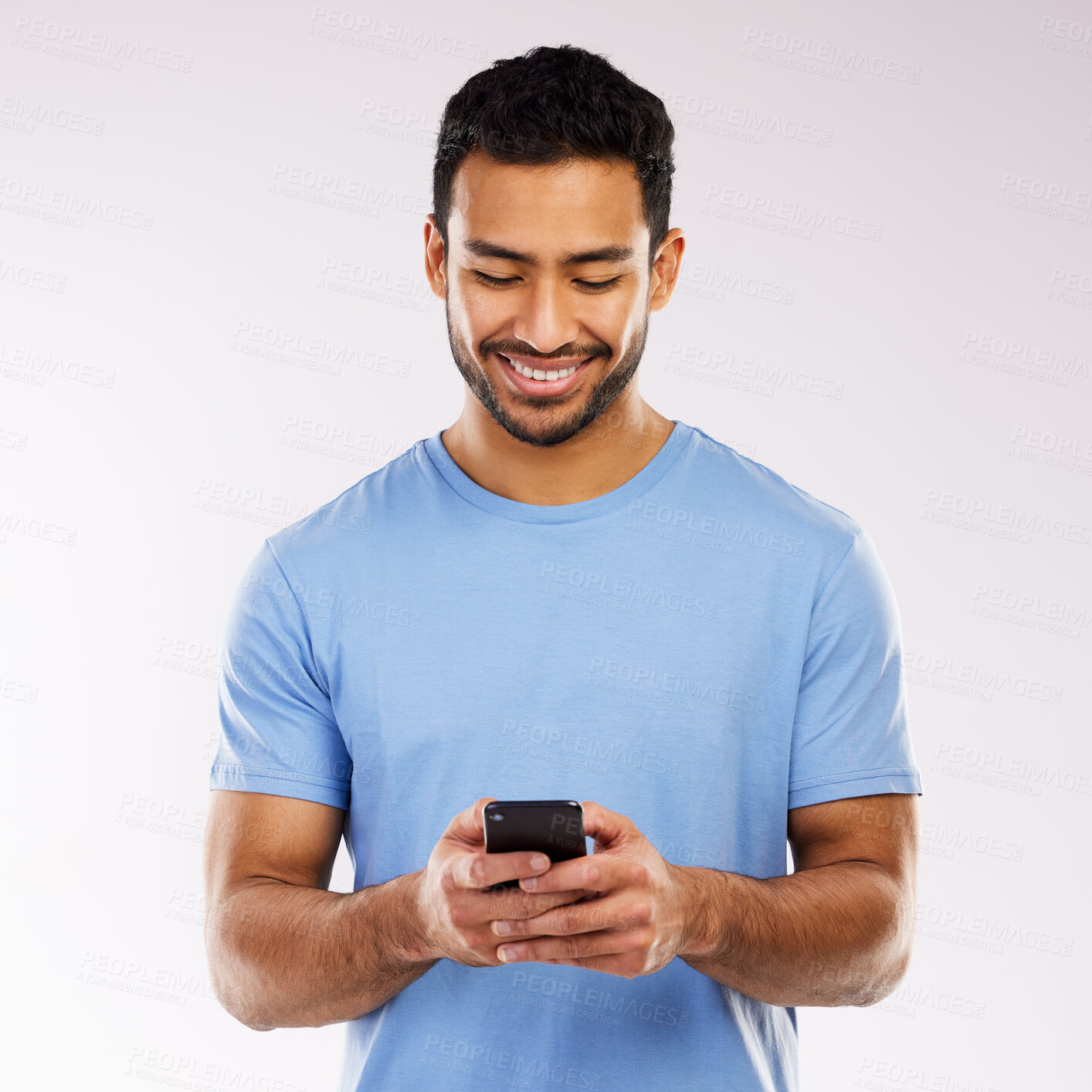 Buy stock photo Studio shot of a young man using a phone against a grey background