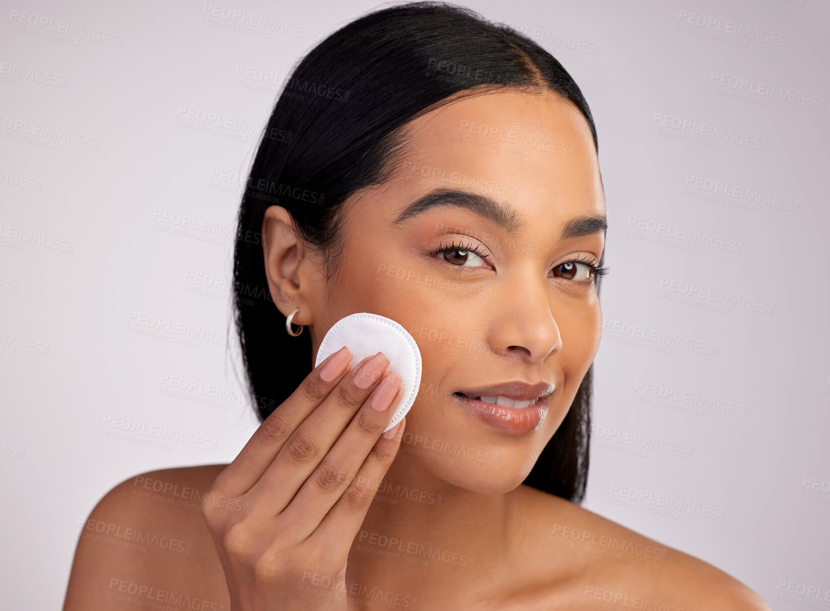 Buy stock photo Happy woman, face and cotton pad in skincare for makeup removal against a grey studio background. Portrait of female person cleaning or wiping product and cosmetics with swab for facial treatment