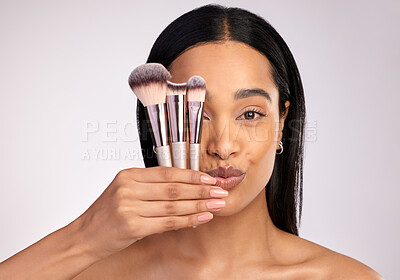 Buy stock photo Woman, portrait and face with makeup brushes in beauty cosmetics against a grey studio background. Female person or model and cosmetic tools, brush or equipment in self love, care or facial treatment
