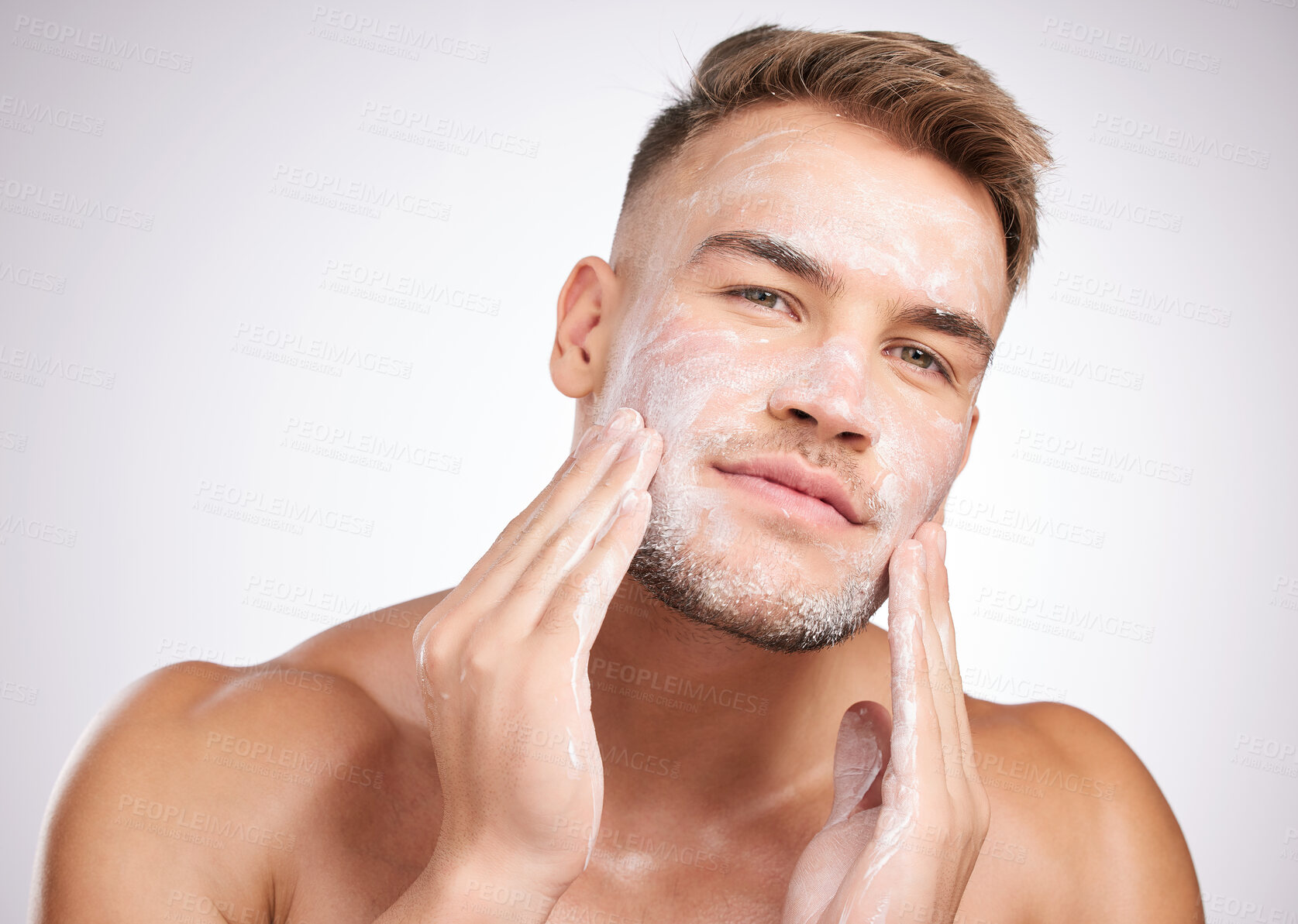 Buy stock photo Studio shot of a young man washing his face against a grey background