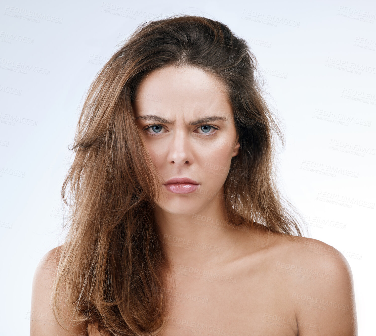 Buy stock photo Portrait, messy hair and frown with an frustrated woman in studio on a white background for beauty. Damage, split ends or frizz and a young person looking unhappy with her haircare treatment