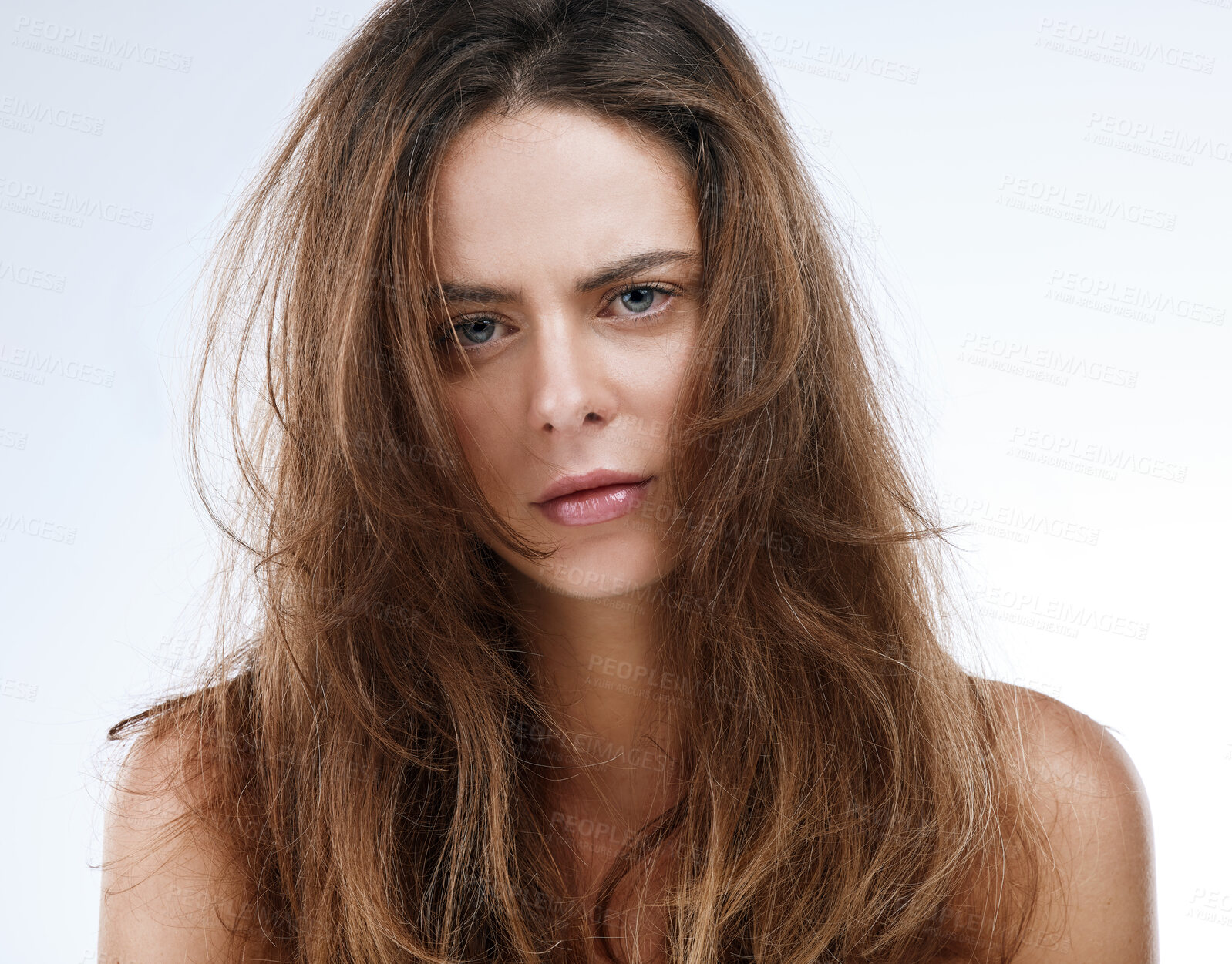 Buy stock photo Portrait, messy hair and frustration with an unhappy woman in studio on a white background for beauty. Damaged, split ends or frizz and a young person looking upset with her haircare treatment