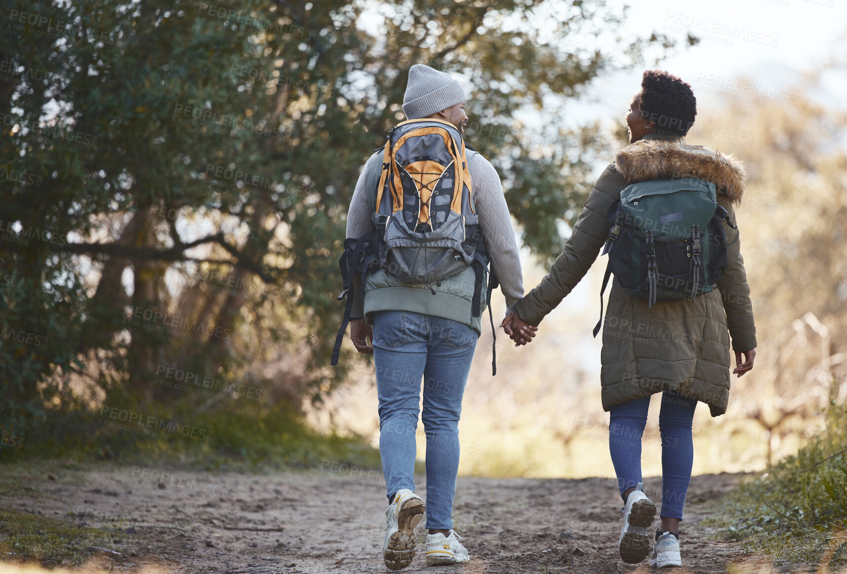 Buy stock photo Shot of a young couple going for a hike during a camping trip