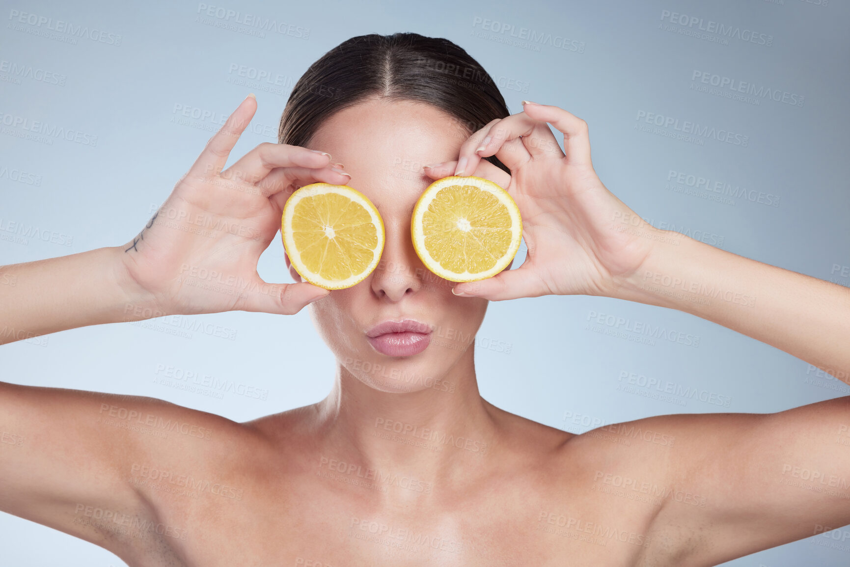 Buy stock photo Lemon, skincare and woman with cover in studio, vitamin c and product for natural exfoliant with results. Blue background, fruit and citric acid for shine of skin, healthy and face wash for person