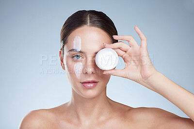 Buy stock photo Woman, container and eye for cream in studio portrait, hydration and beauty on blue background. Female person, jar and apply lotion for facial treatment, skincare and hyaluronic acid moisturizer