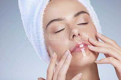 Buy stock photo Studio shot of an attractive young woman using a limp plumper against a grey background