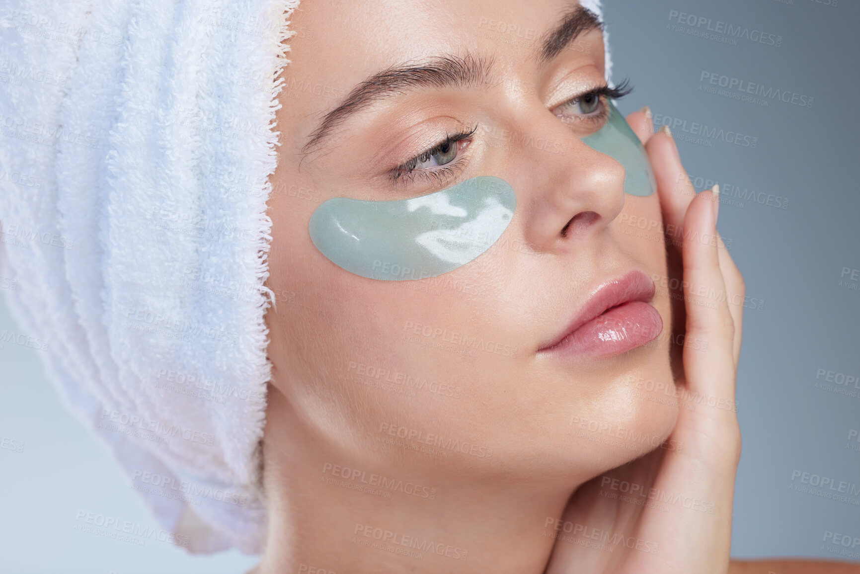 Buy stock photo Woman, eyes and moisturizing patches in studio, facial treatment and hydration on blue background. Female person, skincare and beauty mask for moisture, vitamin e and pads to refresh or cosmetics