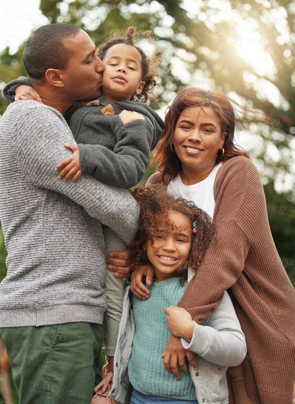 Buy stock photo Parents, children and hug or kiss in outdoor, relax together and affection for love in nature. Family, kids and embrace for security in relationship, happiness and bonding for support in backyard