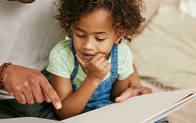 Buy stock photo Shot of a little girl reading a book with her parent at home