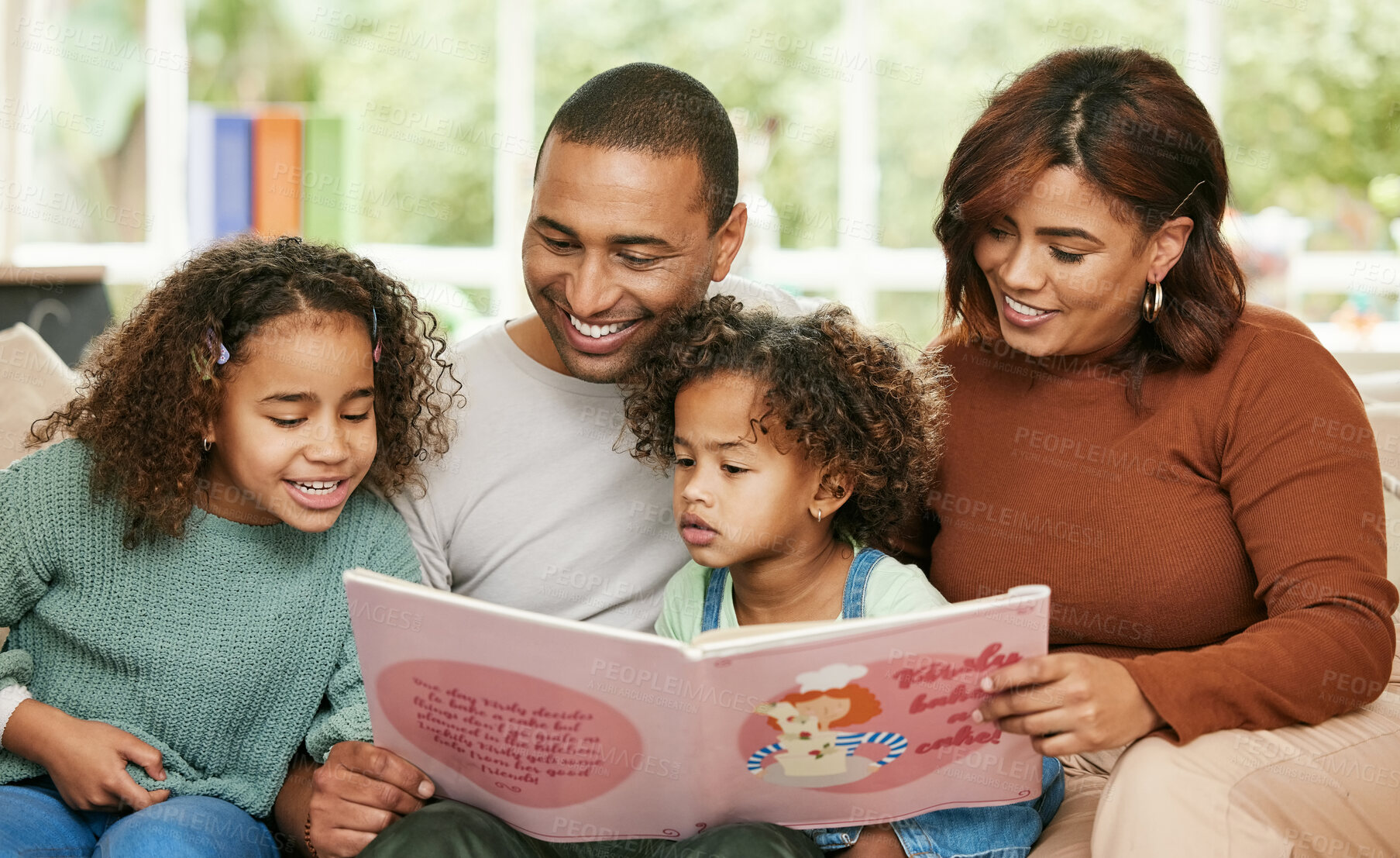 Buy stock photo Shot of a young family reading a book at home