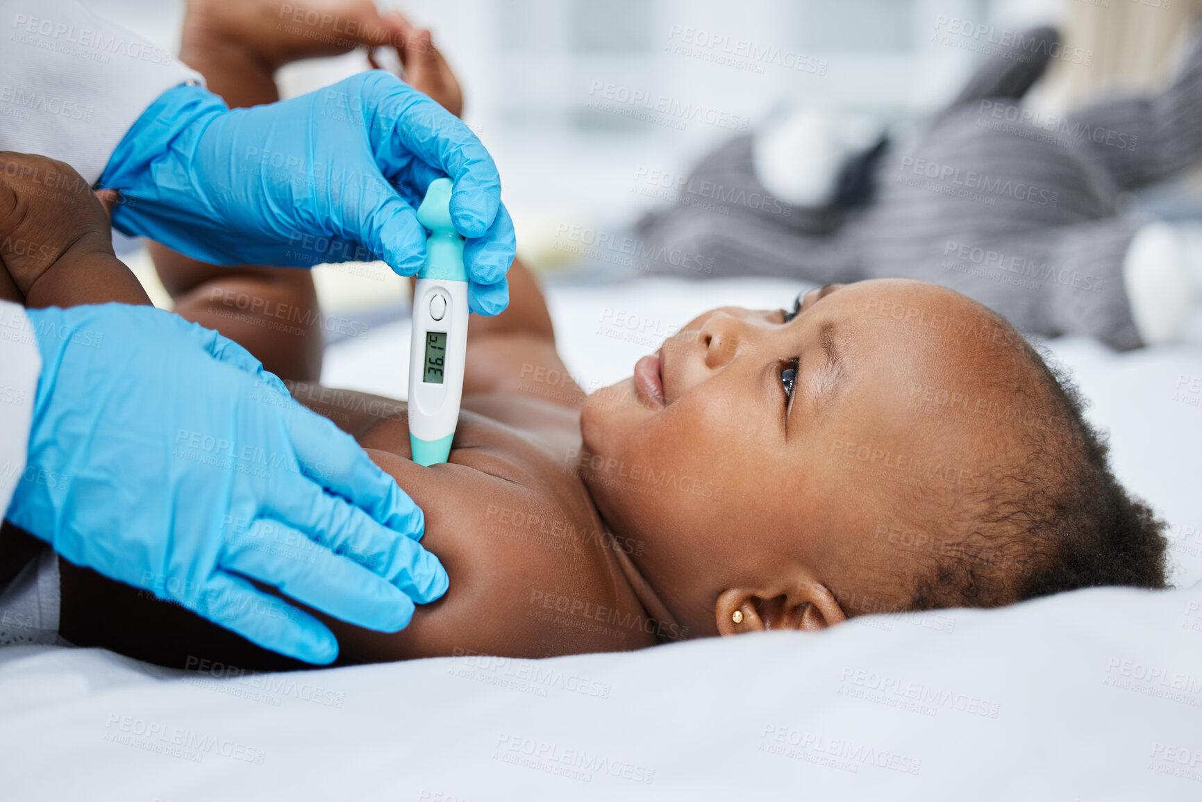 Buy stock photo Shot of a little baby having her temperature taken by a doctor with a thermometer