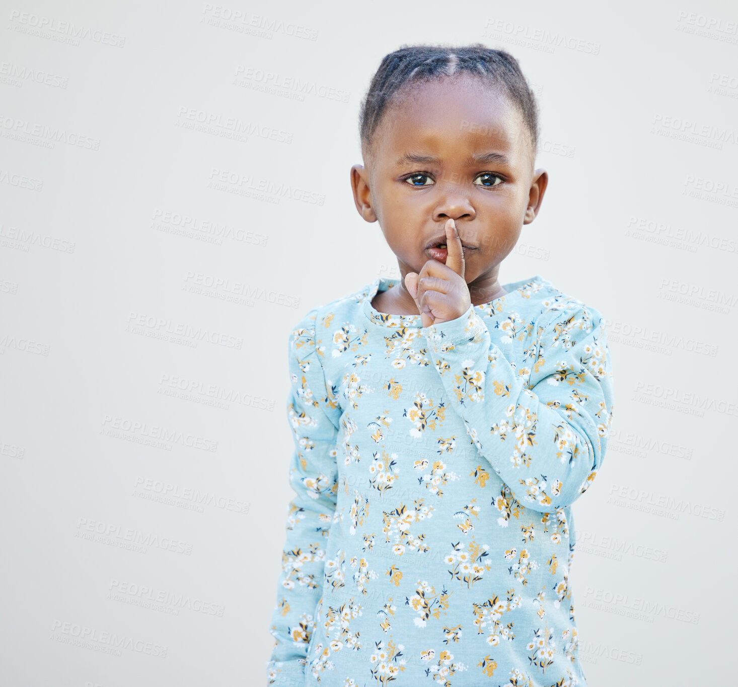 Buy stock photo Child, portrait and finger on mouth for silence with secret, quiet or shush gesture in studio. African girl, youth and emoji for noise, whisper and private story with hand on lips by white background