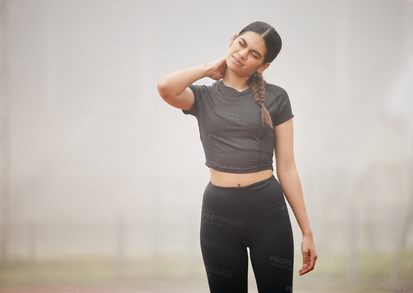 Buy stock photo Shot of an athletic young woman suffering from a sports injury while out on the track