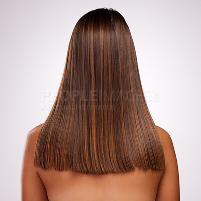 Buy stock photo Studio shot of an unrecognizable young woman standing with her back facing the camera to show off her hair against a grey background