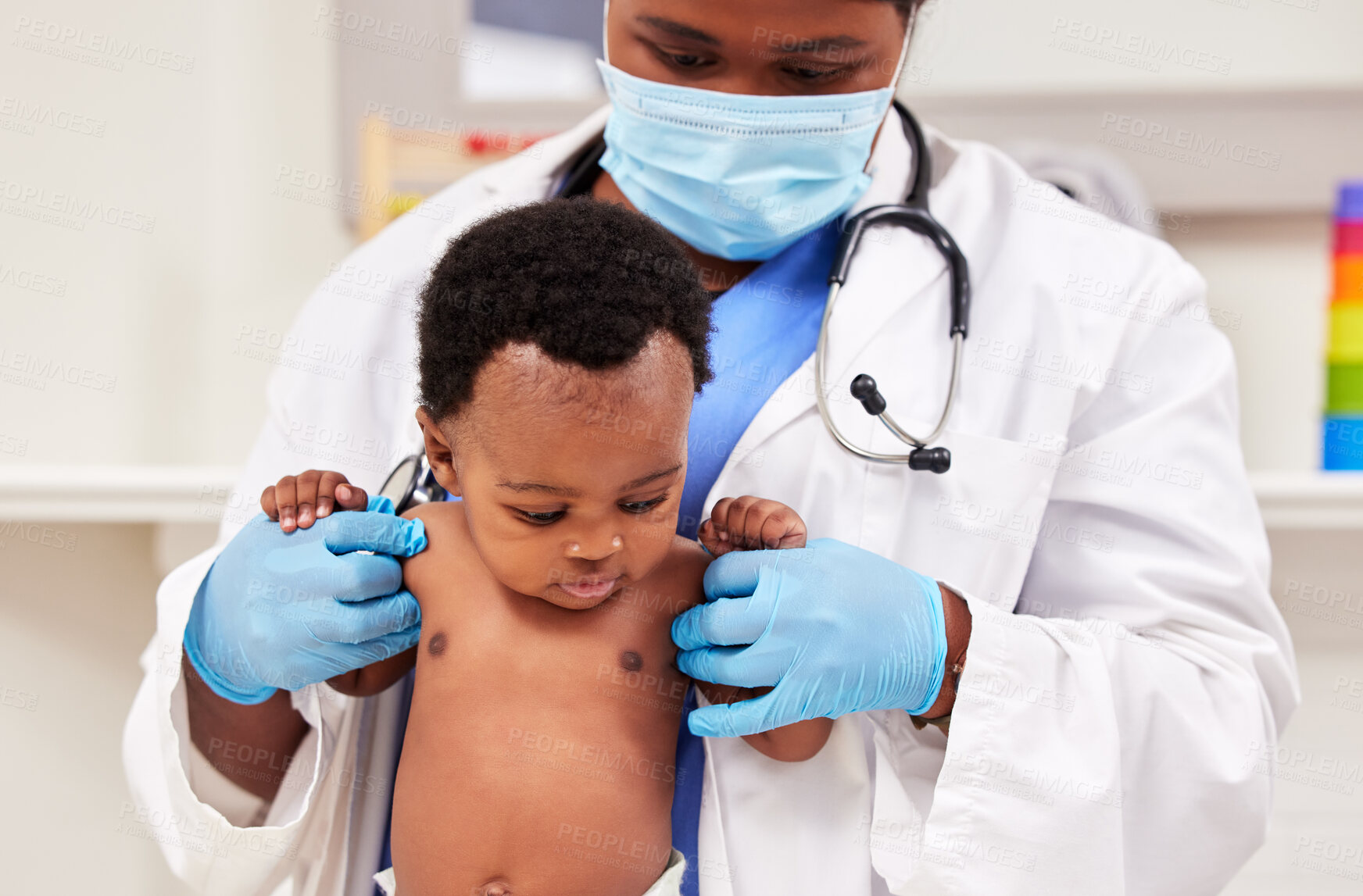 Buy stock photo Shot of a young female doctor doing a checkup on a baby at a clinic