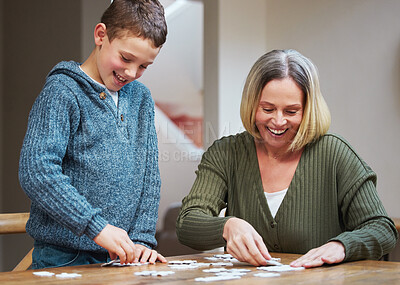 Buy stock photo Shot of a mother completing a puzzle with her son