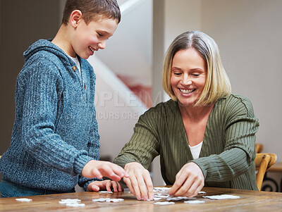 Buy stock photo Shot of a mother completing a puzzle with her son