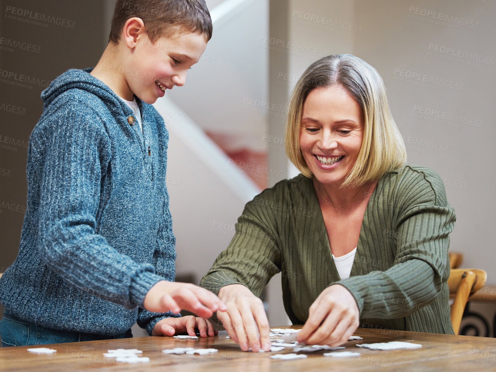 Buy stock photo Shot of a mother completing a puzzle with her son