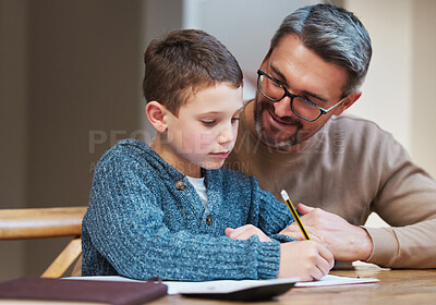 Buy stock photo Shot of a father helping his son complete his homework