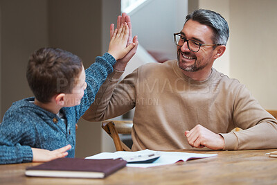 Buy stock photo Shot of a father high fiving his son while they complete his homework