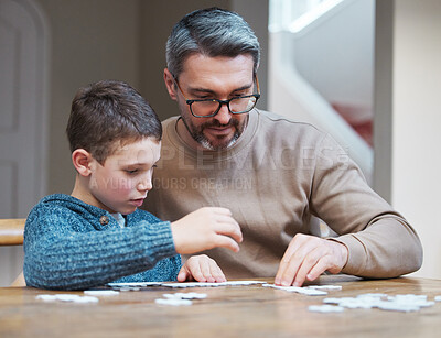 Buy stock photo Shot of a father building a puzzle with his son