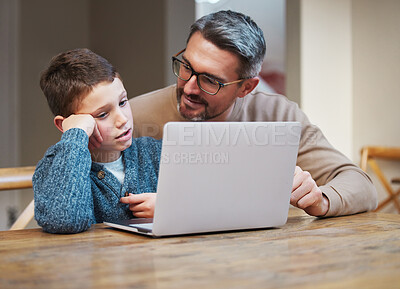 Buy stock photo Shot of a father and son team using a laptop to complete school work