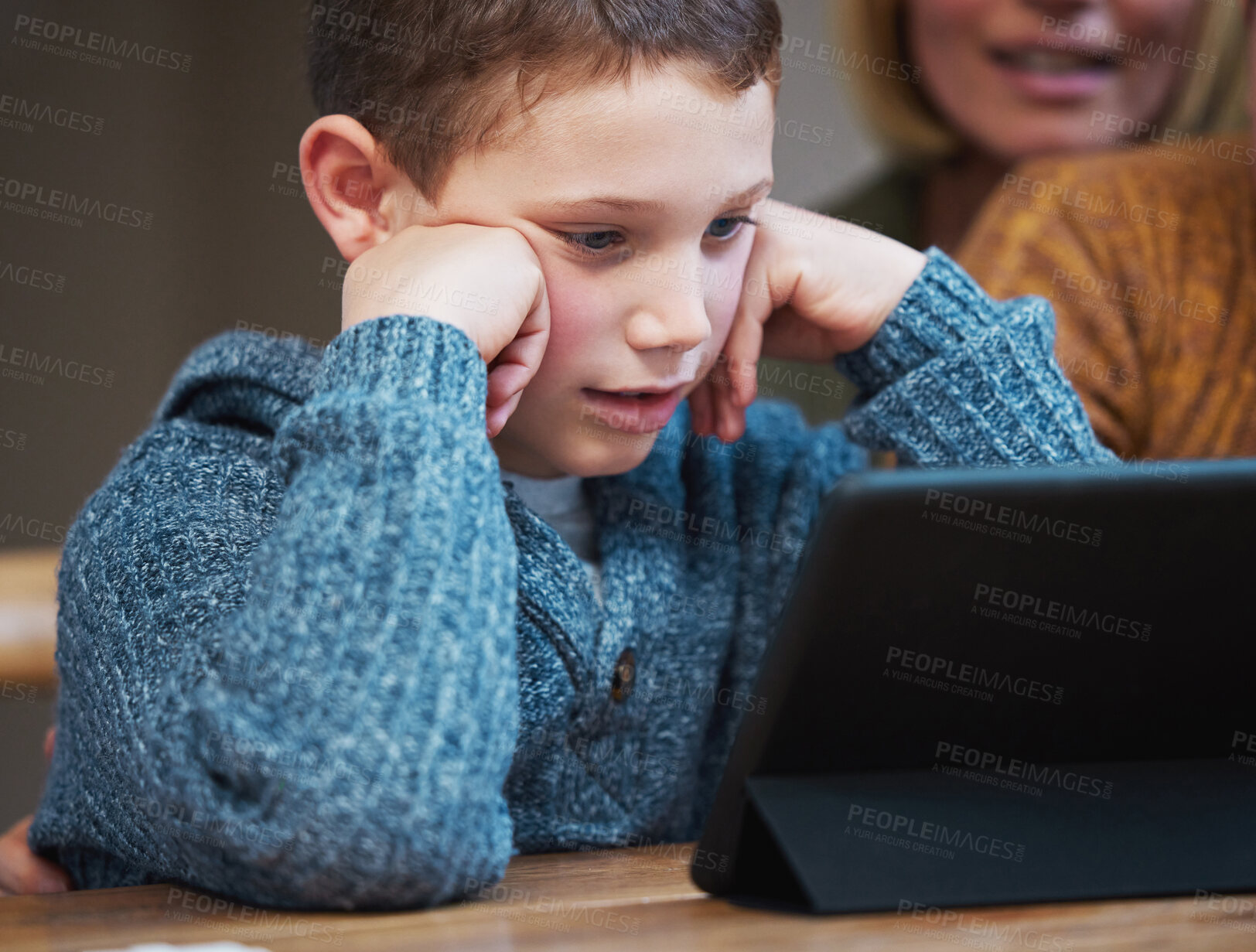 Buy stock photo Shot of a little boy using a digital tablet at home