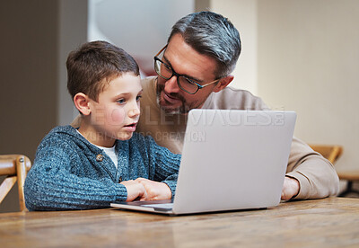 Buy stock photo Shot of a father and son team using a laptop to complete school work