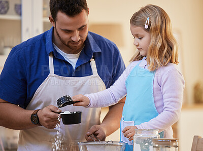 Buy stock photo Shot of a young father helping his daughter measure out flour